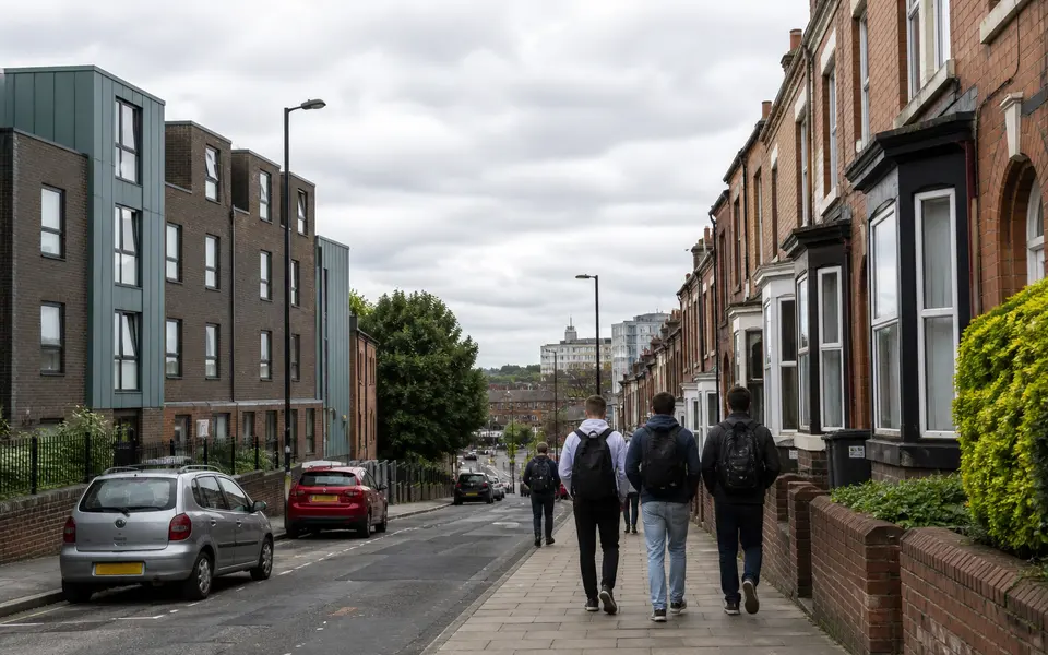 Nottingham city street near a university campus with students walking past a mix of student houses and flats.